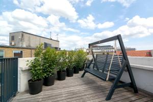 哥本哈根LUXURY Penthouse · Private Balcony · Heart of Copenhagen的坐在种植盆栽植物的阳台的长凳