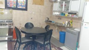 麦地那Madinah Anbariah的厨房配有桌椅和冰箱。