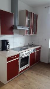 滨湖施图本贝格Ferienwohnung Ronja的厨房配有红色橱柜和炉灶烤箱