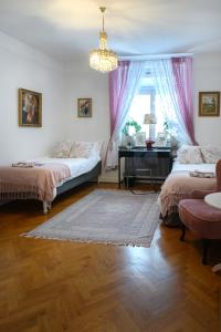 诺尔雪平HoMade B&B, Gamla Stan的一间卧室配有两张床、一张桌子和一个吊灯。