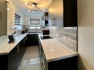 诺丁汉Birkin House - Great for Contractors or Family Holidays的厨房配有白色台面和黑色橱柜