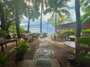 巴希利托Rustic Beach Front Hotel Brasilito的公园里的一排桌子和长椅