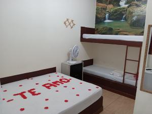 莫埃达Pousada Maravilhas da Serra的客房设有两张双层床,床上铺有红色的心。
