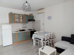 穆泰尔岛Apartmani Rameša的厨房以及带桌子和沙发的客厅。