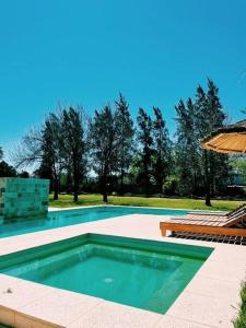 雷孔基斯塔Quinta Las Flores的一个带桌子和遮阳伞的游泳池