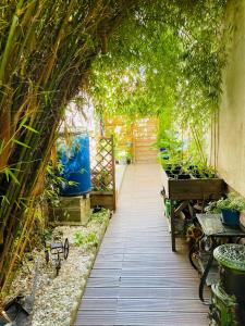 圣吉欧梅斯Studio indépendant de 25m2的花园中种有植物和长凳的拱门