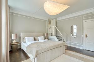 哥本哈根Stylish Spacious Flat w 3BR in Copenhagen City的一间白色的卧室,配有床和楼梯
