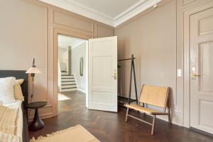 哥本哈根Stylish Spacious Flat w 3BR in Copenhagen City的一间卧室配有一张床、一把椅子和镜子