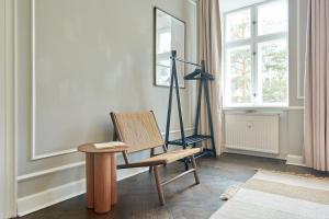 哥本哈根Stylish Spacious Flat w 3BR in Copenhagen City的配有木椅和木桌的房间