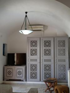 乌姆苏克Dar Ennour Djerbahood Erriadh的一间设有白色墙壁和吊灯的房间