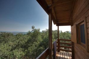 ECOLODGE CABAÑEROS的小木屋的阳台门廊享有风景。