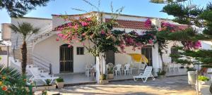 切萨雷奥港Villa Bouganville的白色的房子,有粉红色的鲜花和椅子