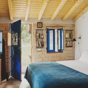 梅利迪什Ponte Pedra - Melides Country House Adults Only的一间卧室配有床和蓝色窗帘的窗户