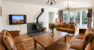 科尼斯顿Sawmill Cottage, Coniston Water的客厅配有桌子和壁炉