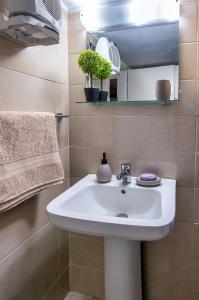 依克希亚Anali Apartment的浴室设有白色水槽和镜子