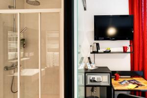 Trie sur Baise国际之家罗夫特酒店的带淋浴的浴室和墙上的电视