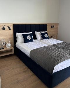 尼苏利采Lago Apartamenty Domki的一间卧室配有一张带蓝白色枕头的大床