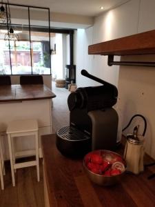克莱蒙费朗Maison hypercentre calme, terrasse, garage, poêle的咖啡壶和柜台上的一碗水果