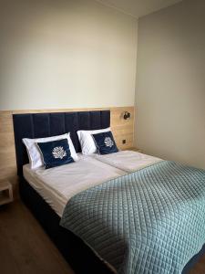 尼苏利采Lago Apartamenty Domki的一间卧室配有一张带蓝白色枕头的大床