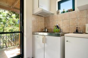 米克罗斯雅洛斯Vardia studio B的厨房配有白色橱柜、水槽和窗户。