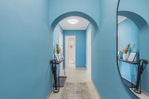慕尼黑PRIME: Design Apartment für 4 - Zentrale Lage的走廊设有蓝色的墙壁和镜子