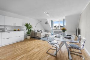 慕尼黑PRIME: Design Apartment für 4 - Zentrale Lage的厨房以及带桌椅的起居室。