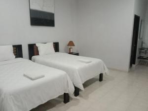 金巴兰巴厘岛普里哈苏酒店的客房内的两张床和白色床单