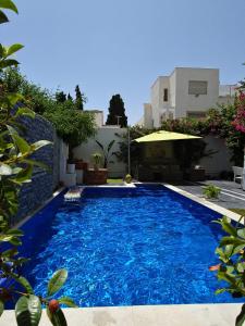 纳布勒Villa de Charme Adultes Only的大楼前的大型蓝色游泳池