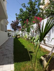 纳布勒Villa de Charme Adultes Only的白色围栏旁的粉红色花卉花园