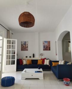 纳布勒Villa de Charme Adultes Only的客厅配有蓝色的沙发和桌子