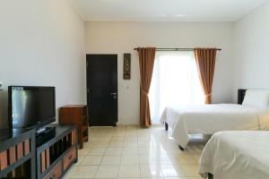 金巴兰巴厘岛普里哈苏酒店的酒店客房设有两张床和一台平面电视。