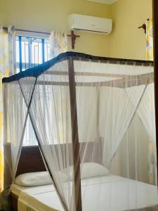 帕杰Mbuyu Uvi Apartment的一张带天蓬的床