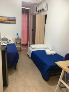 夏卡Casa di Angela的一间卧室配有两张带蓝色床单的床和一张桌子