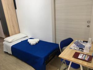 夏卡Casa di Angela的一间设有蓝色床和一张桌子的小卧室