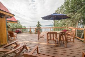 Marsh Lake湖上酒店 - 白马的木制甲板配有桌椅和遮阳伞