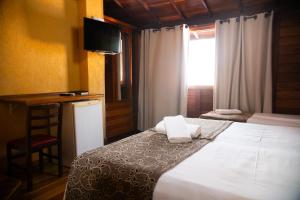尼泰罗伊伊泰普沙丘旅馆的一间卧室配有一张床和一个带椅子的窗户
