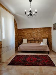 桑布卡迪西奇利亚Le Stanze dell'Emiro的一间卧室配有一张床和一个吊灯