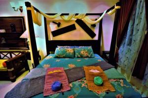 古晋Boutique Studio with exclusive views and amenities的一间卧室配有一张带色彩缤纷的毯子和枕头的床。
