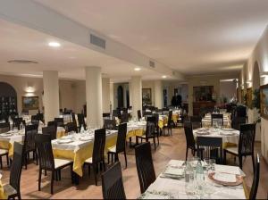 洛雷托Vecchia Fattoria的用餐室配有桌椅和黄色桌布