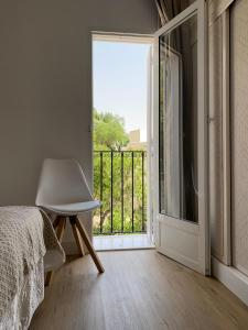莫哈卡尔Apartamento PLAYA LAS VENTANICAS的一间卧室设有一张床、一个窗口和一把椅子