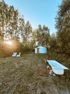 EikažiGlamping Yurt Purvs at Kleja Quiet Camping的蓝色帐篷和田野内的浴缸