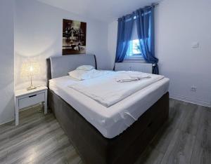 汉诺威Restaurant Donau的一间卧室配有一张带蓝色窗帘的大床