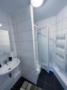 汉诺威Restaurant Donau的白色的浴室设有水槽和淋浴。