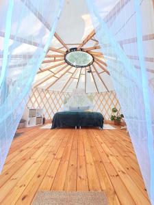 EikažiGlamping Yurt Purvs at Kleja Quiet Camping的蒙古包内带一张床的房间