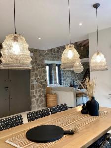 达西亚Villa Tartaya的厨房配有3盏吊灯和一张木桌