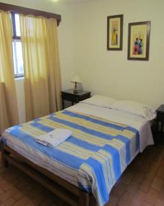 万查科Huanchaco Hostal的一间卧室配有一张带蓝白色毯子的床