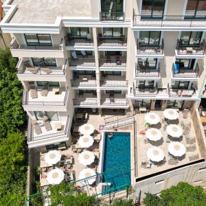 布德瓦Hotel Pima Budva的享有带游泳池和遮阳伞的建筑的空中景致