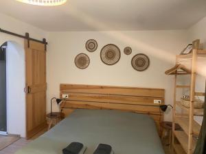 滨海苏拉克L'Océanaise的一间卧室配有一张床,墙上挂着一些帽子