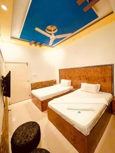 卡拉奇Rehaish Inn的客房设有两张床和天花板。