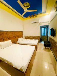 卡拉奇Rehaish Inn的一间卧室配有两张床和吊扇